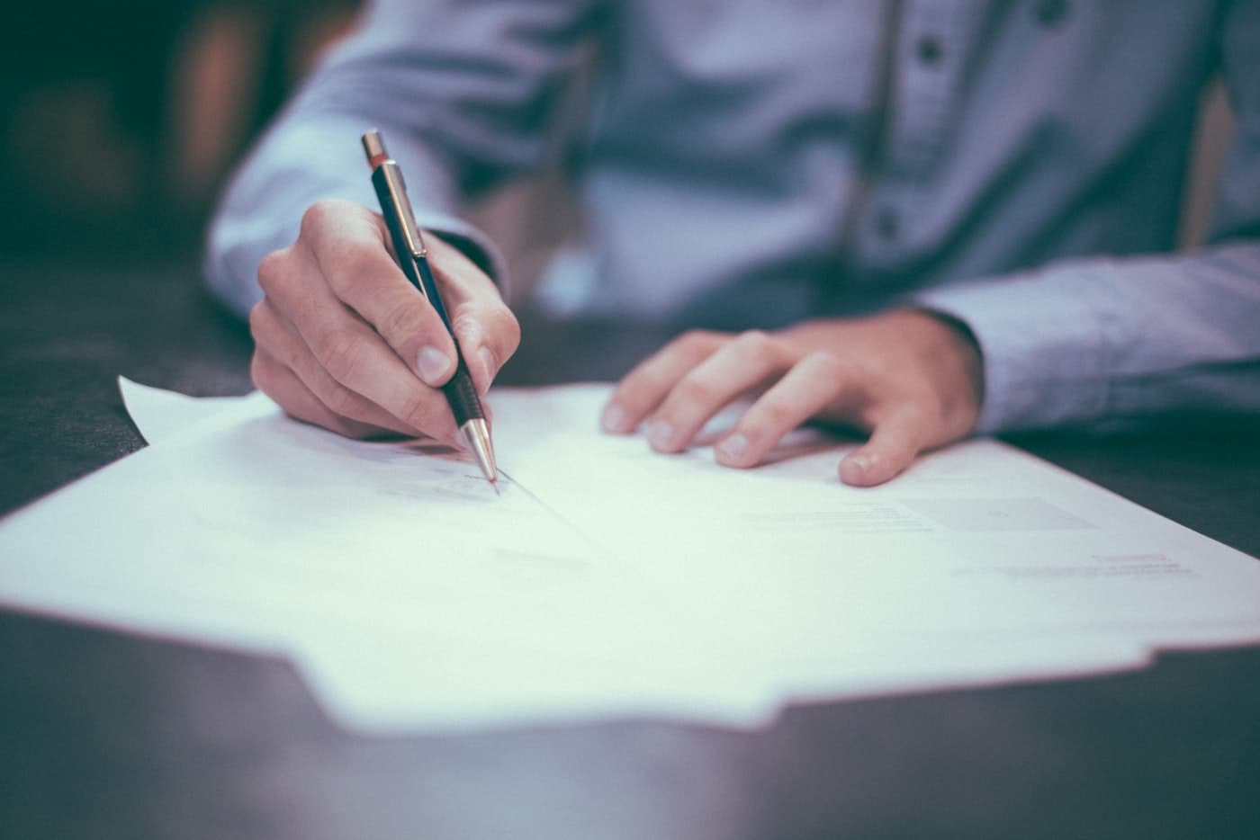 Close-up of a professional signing legal documents with a fountain pen